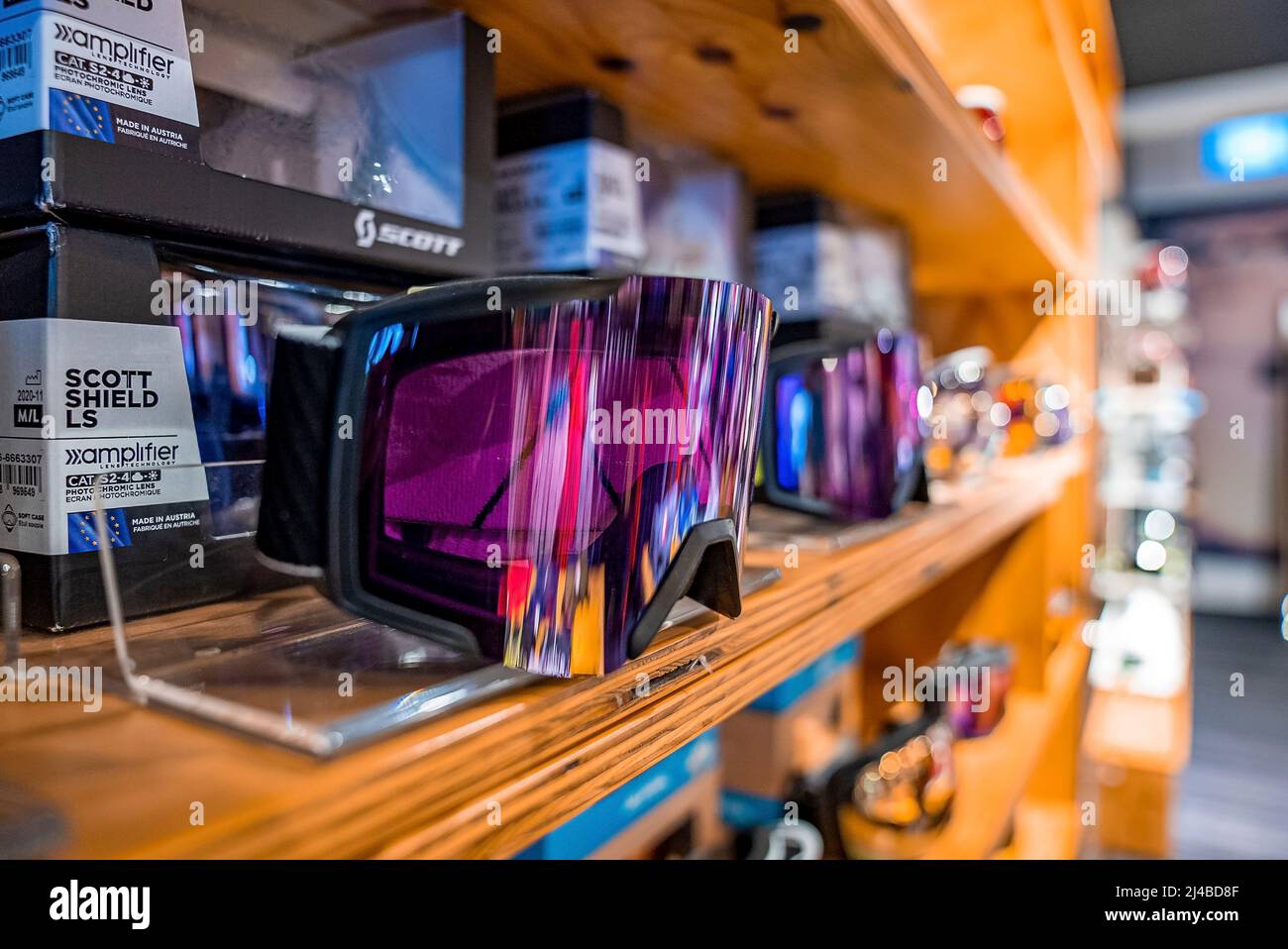 Variedad de gafas de esquí en estanterías de madera en una tienda de equipos deportivos Foto de stock