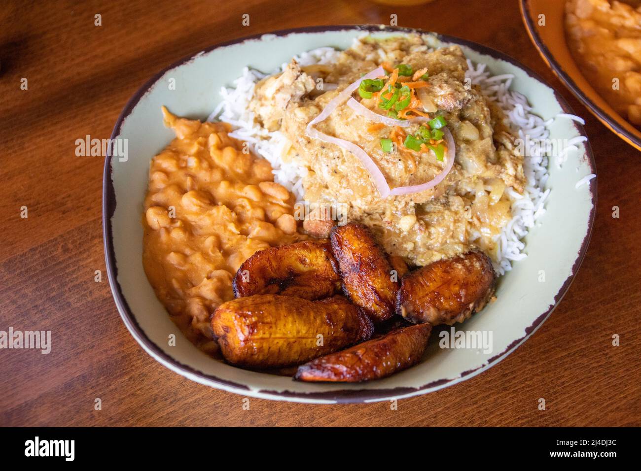 Kuku, pollo en salsa rica, picante de mostaza y cebolla, restaurante Baobab Fare, Detroit, MI, ESTADOS UNIDOS Foto de stock