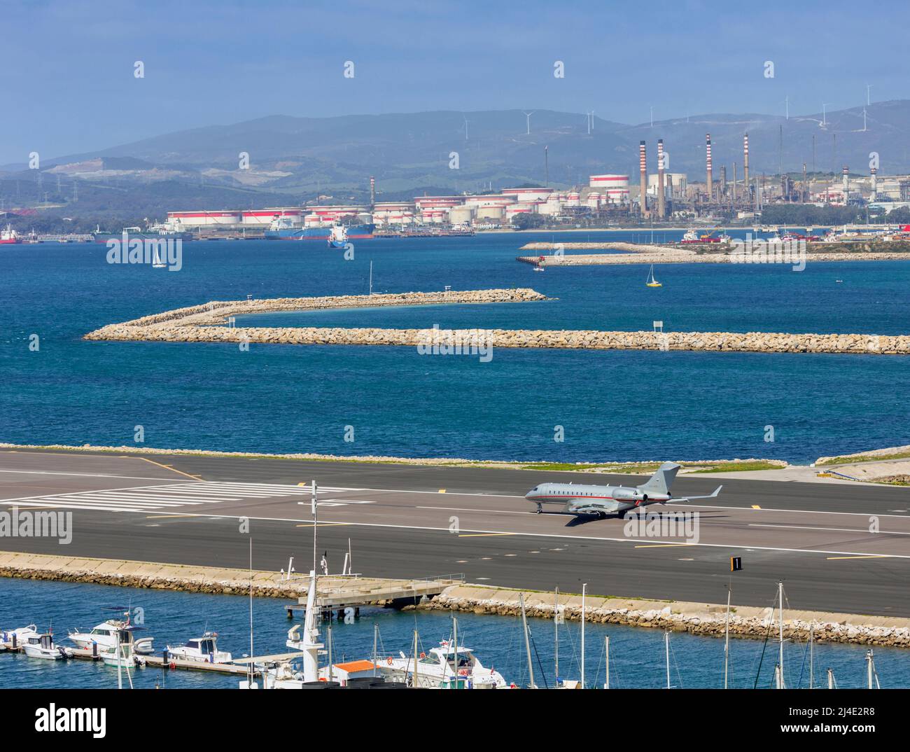 Avión del operador global de vuelos chárter VistaJet que aterriza en el aeropuerto de Gibraltar. Algeciras, España en el fondo. Foto de stock