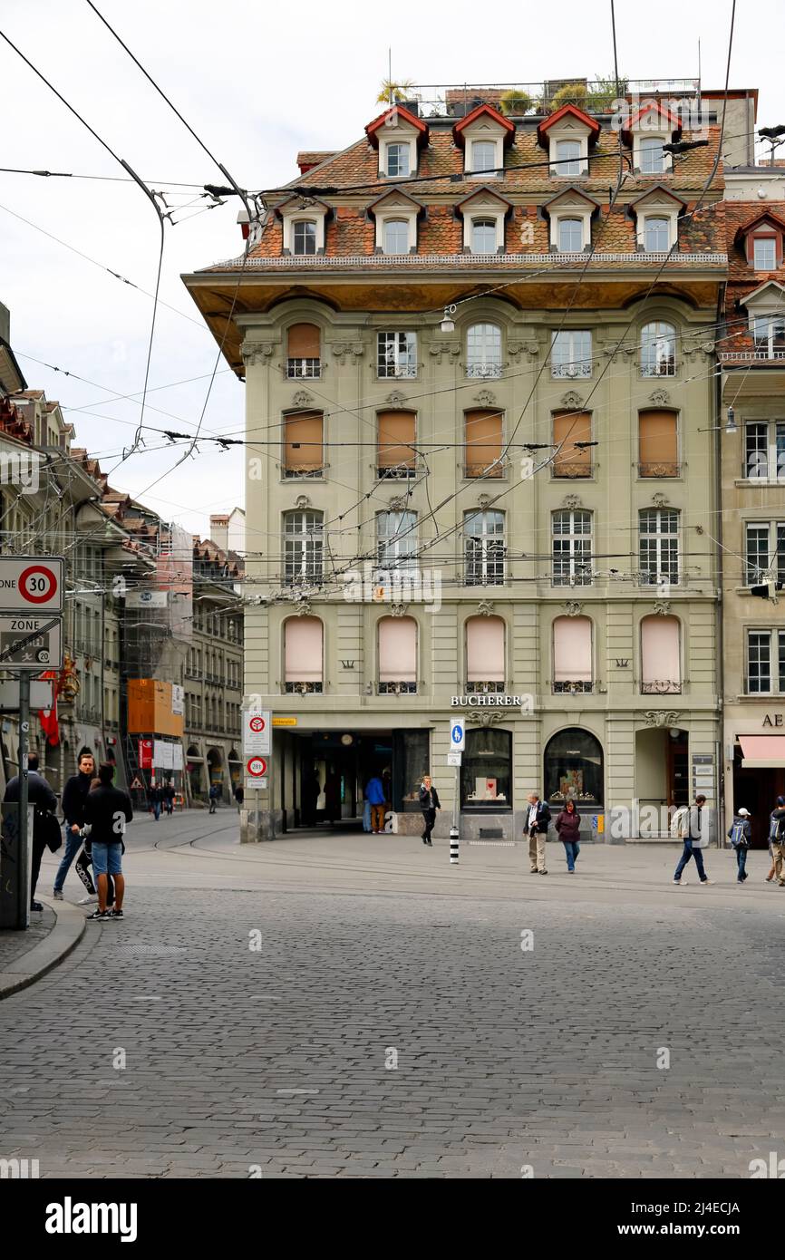 Berna, Suiza - 17 de abril de 2017: Casa de inquilinos en el casco antiguo. La infraestructura eléctrica del sistema de tranvías es visible por encima de la calle Foto de stock