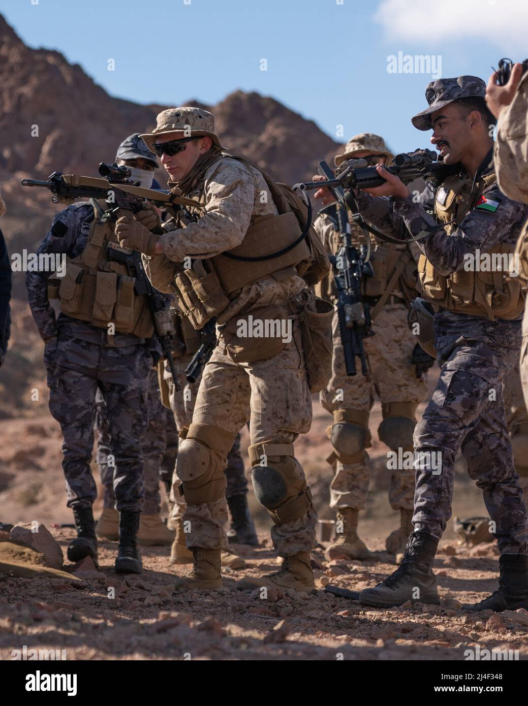 CAMPAMENTO DE TITIN, Jordania (15 de marzo de 2022) - Marines de EE.UU. Con 2nd Batallón, 24th Marines y Marines jordanos del Real Batallón Marino Jordano de 77th compiten en un desafío de recarga de velocidad de municiones durante el ejercicio Intrepid Maven (IM) 22-1, a bordo de Camp Titin, Jordania, marzo de 15. IM es una serie de compromisos bilaterales entre las Fuerzas del Cuerpo de Infantería de Marina de los Estados Unidos, el Mando Central y las Fuerzas Armadas Jordanas (JAF) que ofrece la oportunidad de intercambiar tácticas militares y experiencia. IM 22-1 es el primero de los múltiples compromisos programados entre el Cuerpo de Marines de Estados Unidos y el JAF para aumentar la interoperabilidad Foto de stock