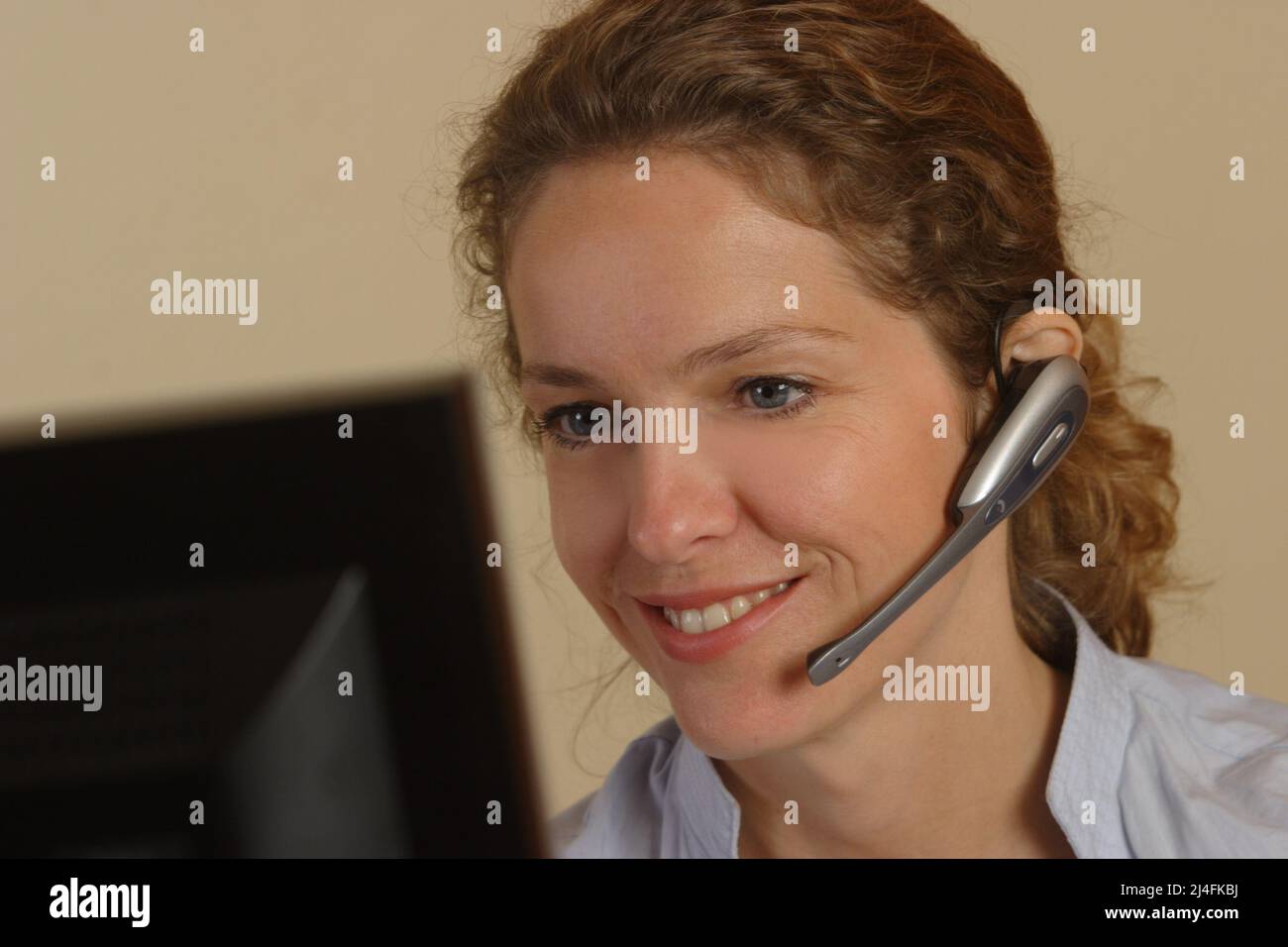 mujer joven que trabaja con auriculares Foto de stock
