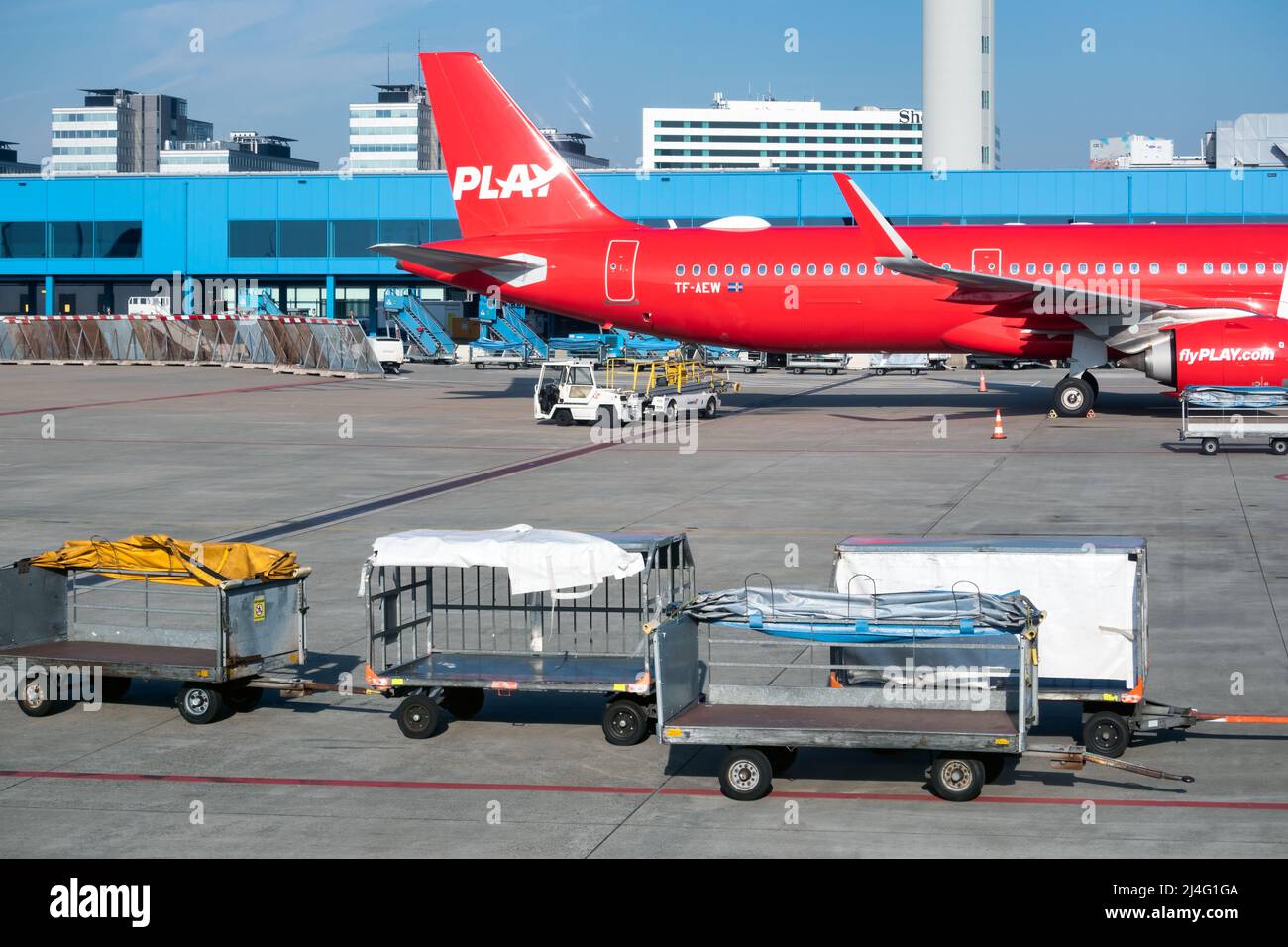 Schiphol, Países Bajos - 02 de marzo de 2022: Aviones esperando en la puerta para subir a bordo de los pasajeros y el carrito de equipajes en frente Foto de stock