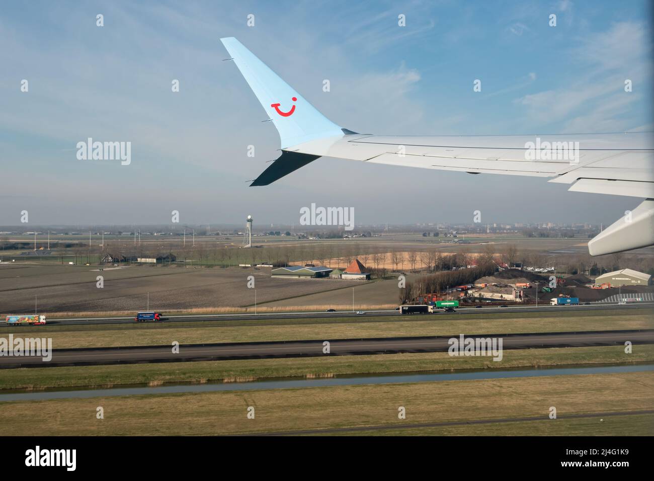 Schiphol, Países Bajos - 02 de marzo de 2022: Ala de avión y autopista holandesa con juist de campo después del despegue en el aeropuerto de Schiphol Foto de stock