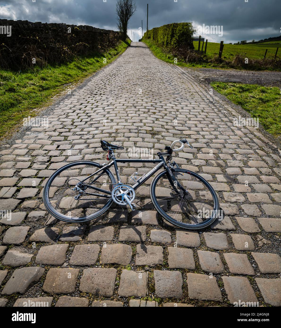 Ribble bicicleta de carretera en una carretera empedrada, Lancashire, Reino Unido. Foto de stock