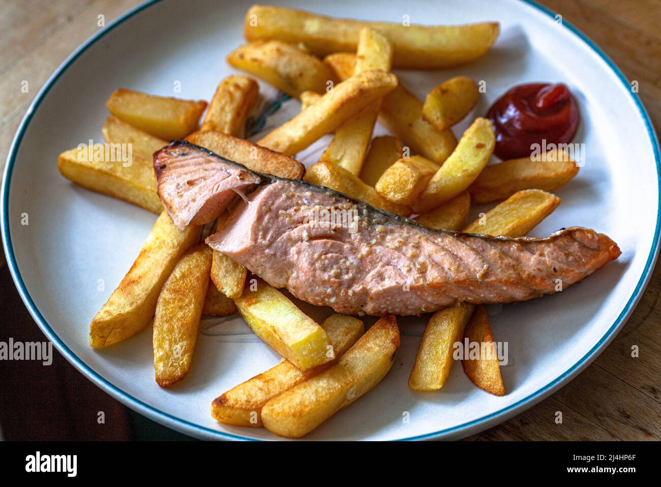 Un plato con pescado casero y patatas fritas. Foto de stock