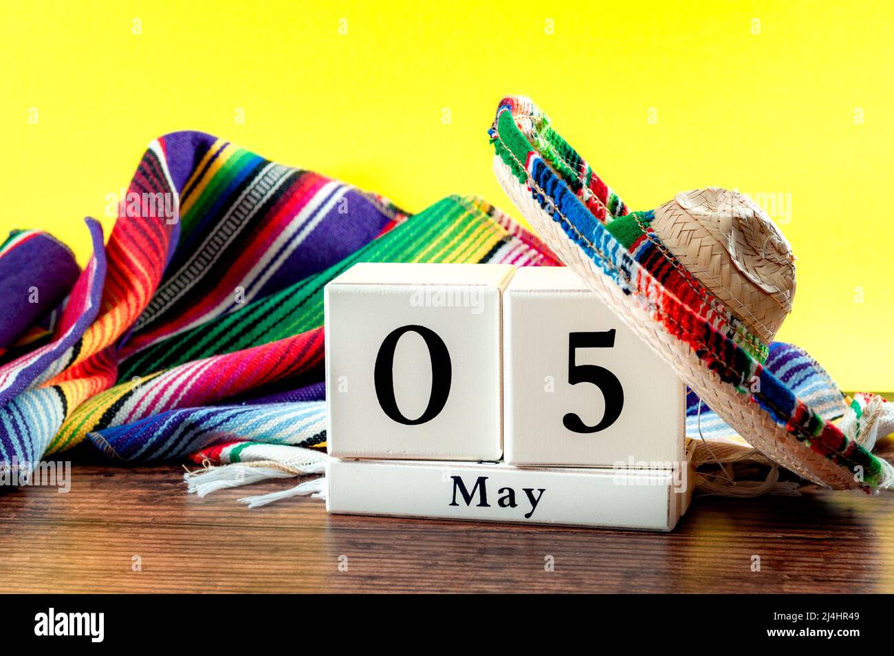 Celebración del cinco de Mayo y la fiesta mexicana idea conceptual con sombrero auténtico (sombrero), alfombra de colores tradicionales (serape) y calendario en bloque Foto de stock