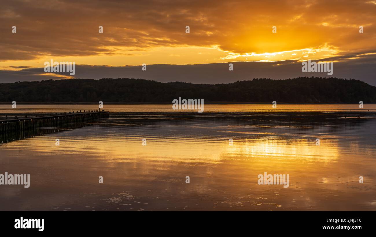 Puesta de sol sobre la costa de Jasmuder Bodden en Lietzow, Mecklemburgo-Pomerania Occidental, Alemania Foto de stock