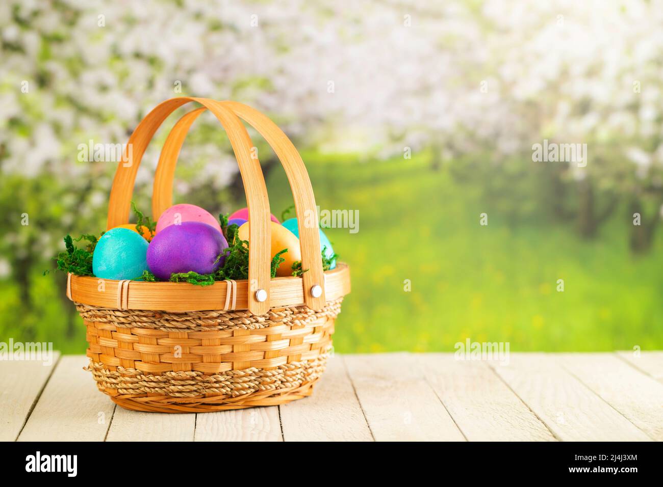 Cesta llena de coloridos huevos duros de Pascua Foto de stock