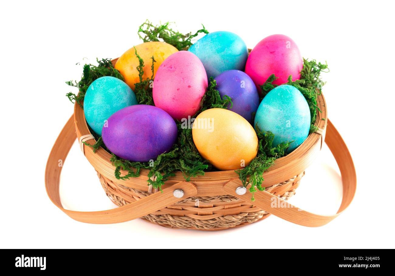 Cesta llena de coloridos huevos duros de Pascua Foto de stock