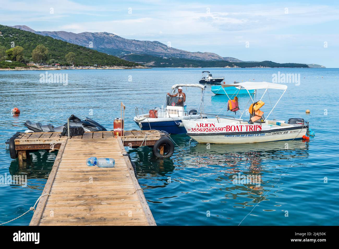 Ksamil, Albania - 9 de septiembre de 2021: Muelle de madera y barcos en la playa paraíso Ksamil en Albania. Azure mañana paisaje marino de mar Jónico. Concepto de vacaciones Foto de stock