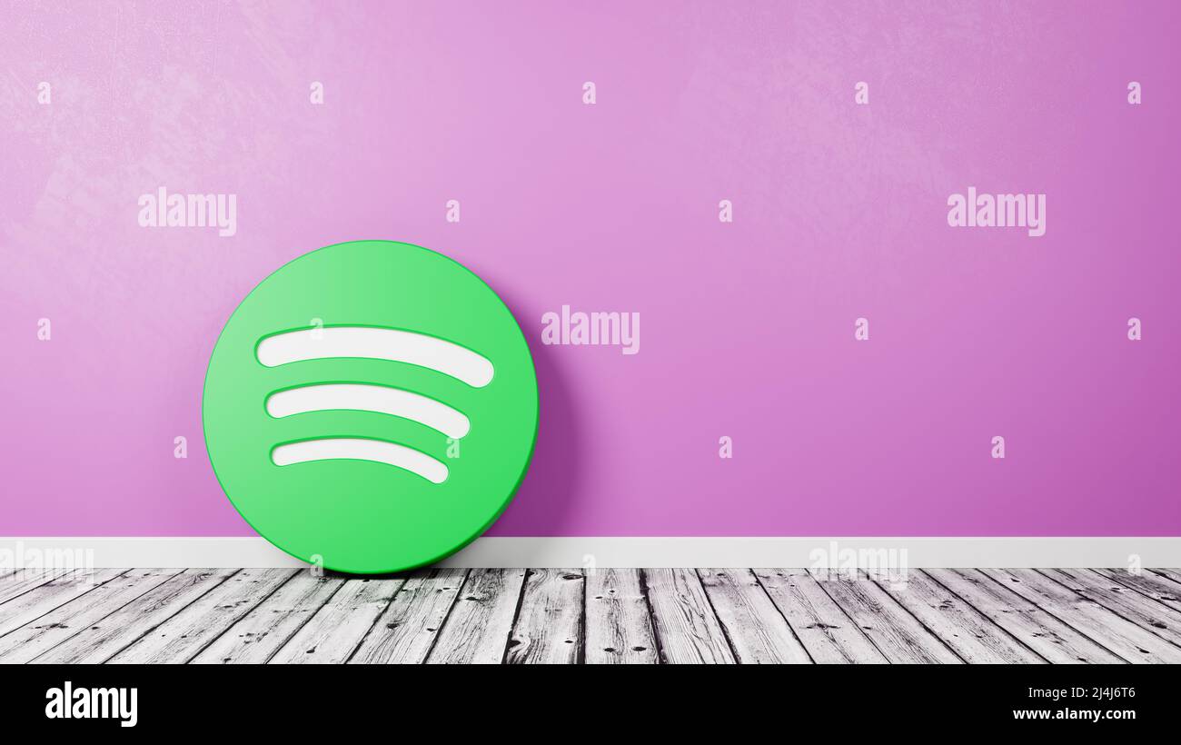 Logotipo de Spotify en suelo de madera contra pared Foto de stock