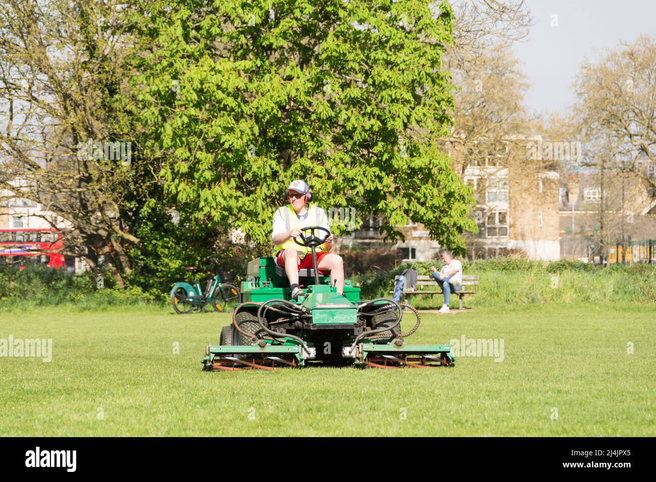 Un hombre de tierra segando la hierba en Putney Common usando un cortacéspedes de cilindro de Ransomes Highway Foto de stock