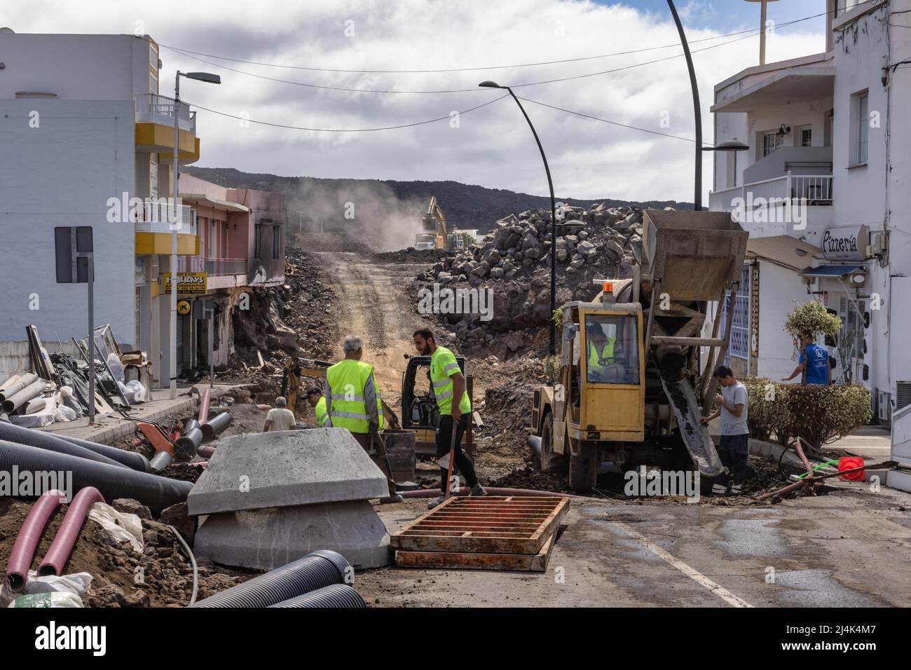 Isla de La Palma España - 03 de marzo de 2022: Hombres en el trabajo limpiando el camino cubierto de lava después de la erupción volcánica de Cumbre Vieja Foto de stock