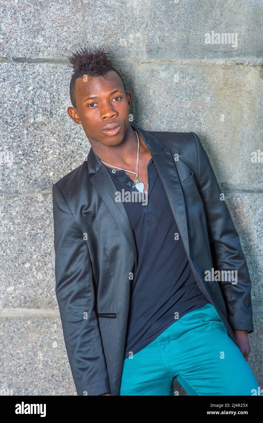 Vestirse en un blazer negro, pantalones verdes, un joven negro con pelo  mohawk se inclina contra la pared, su cuerpo inclinado un lado, mirando con  confianza Fotografía de stock - Alamy