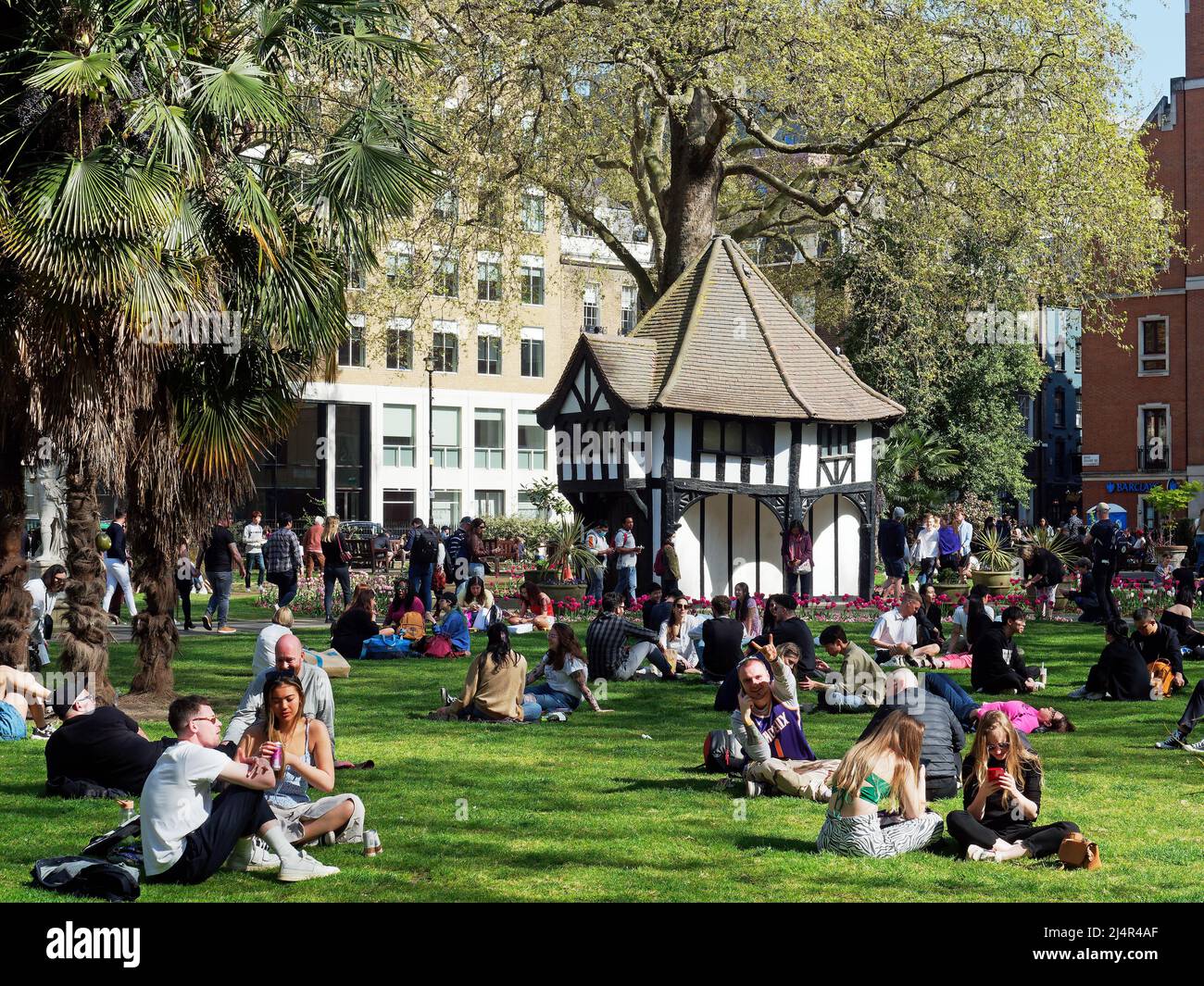 Una vista de la gente que se relaja en un soleado día de primavera en Soho Square Gardens en Londres, Reino Unido Foto de stock