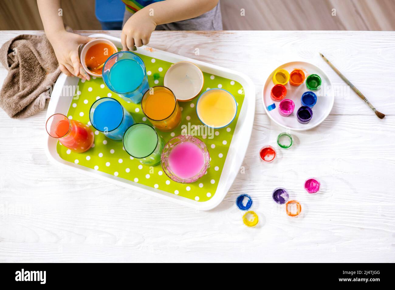 Lindo niño aprendiendo mezclando diferentes colores con agua y pintura en  recipientes. Desarrollo temprano Fotografía de stock - Alamy
