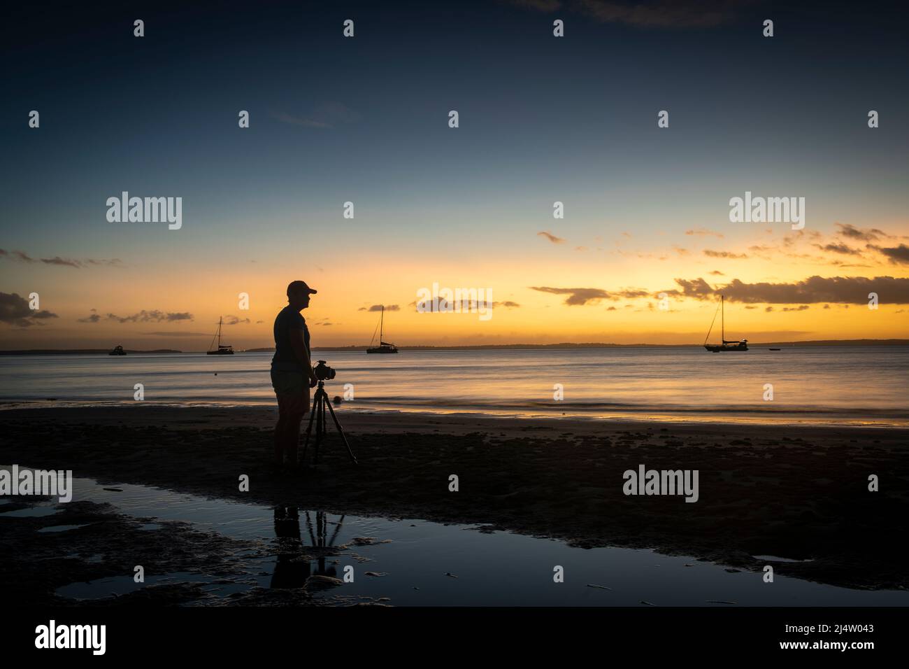 Un fotógrafo haciendo fotos al atardecer en Kingfisher Bay en Fraser Island, Queensland, Australia. Foto de stock