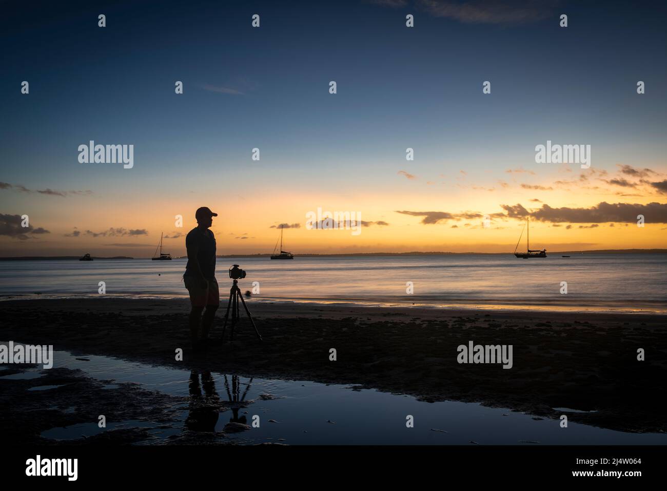 Un fotógrafo haciendo fotos al atardecer en Kingfisher Bay en Fraser Island, Queensland, Australia. Foto de stock