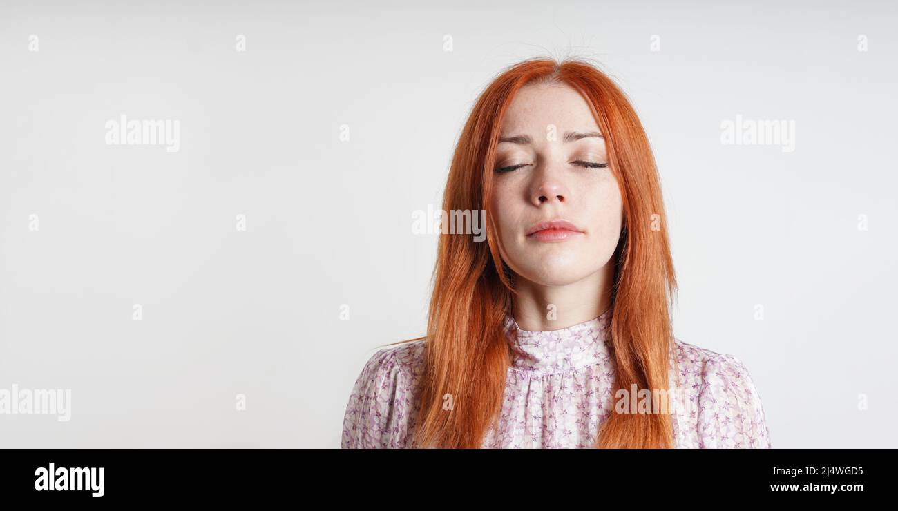 Una mujer tranquila y pacífica medita con ojos cerrados - introspección atención y auto-cuidado Foto de stock