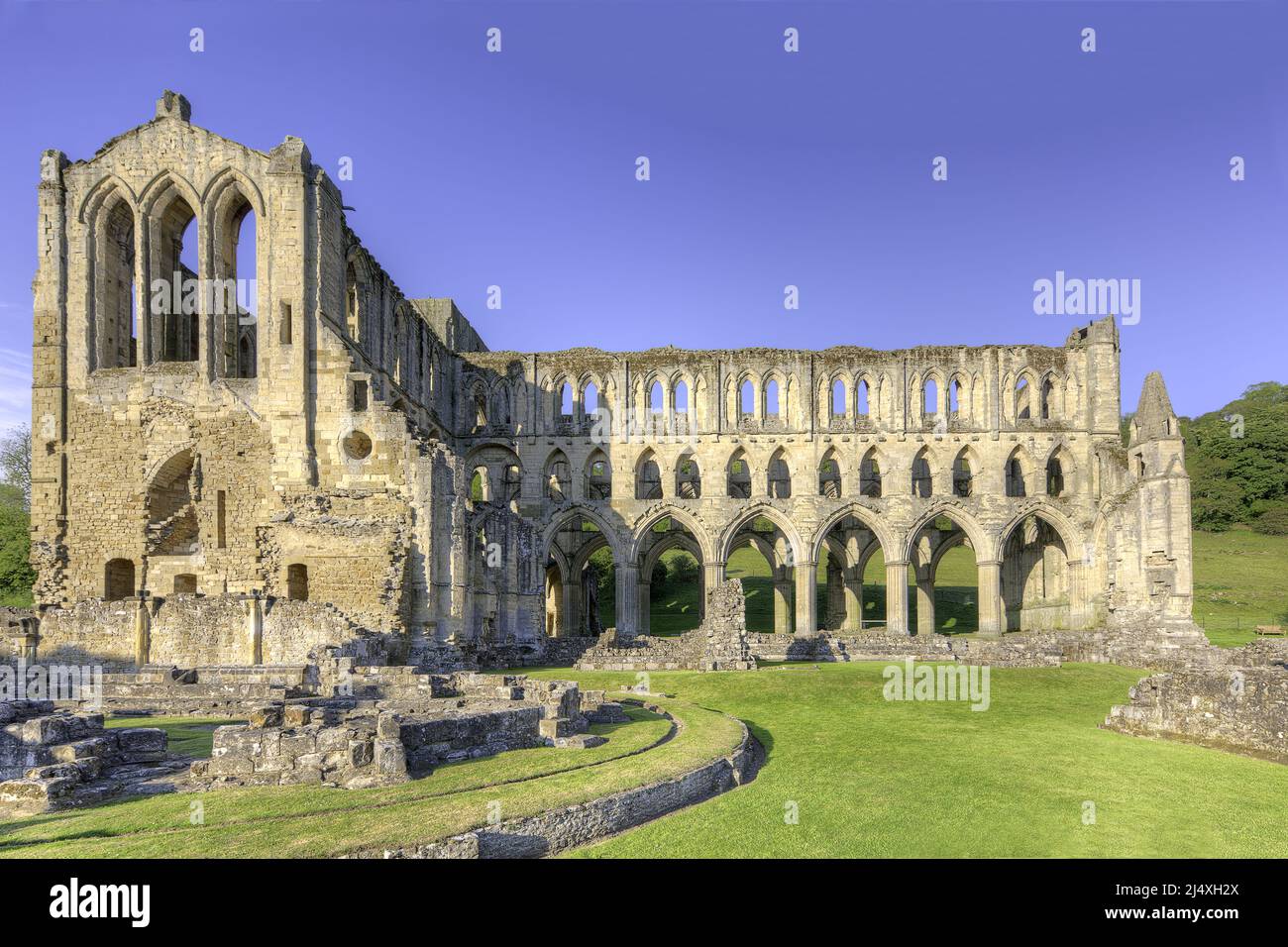 Presbiterio y crucero sur con la ruina de Chapter House (L primer plano) de la abadía cisterciense de Rievaulx en ruinas fundada 1132 - suprimida 1538. Foto de stock
