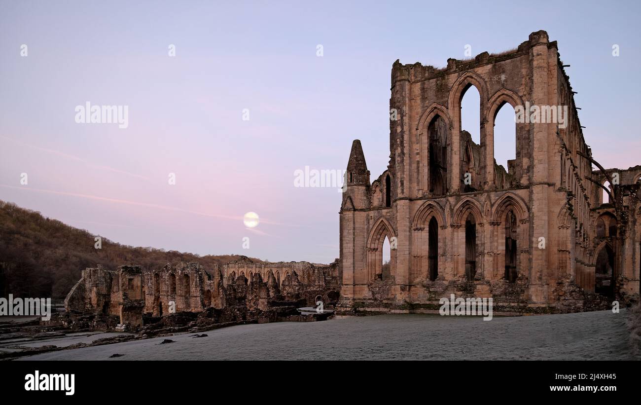 Presbiterio, ruinas de enfermería (primer plano izquierdo) y detrás de que el refectorio de la abadía cisterciense de Rievaulx en ruinas. Antes del amanecer después de la subida de la luna Foto de stock