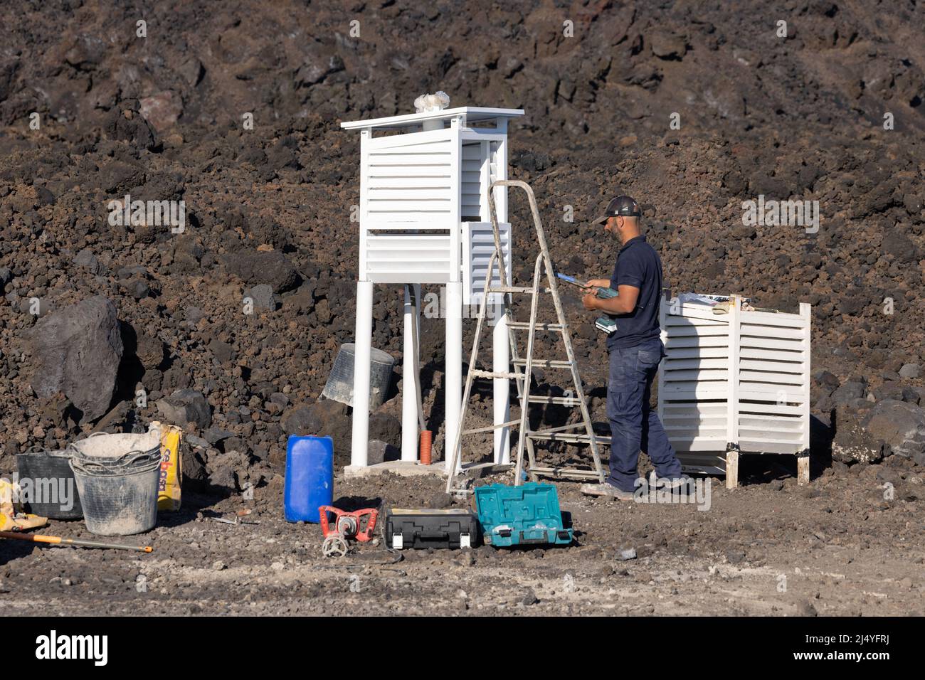 Isla La Palma España - 08 de marzo de 2022: Hombre en el trabajo construyendo una cubierta protectora para instrumentos meteorológicos Foto de stock