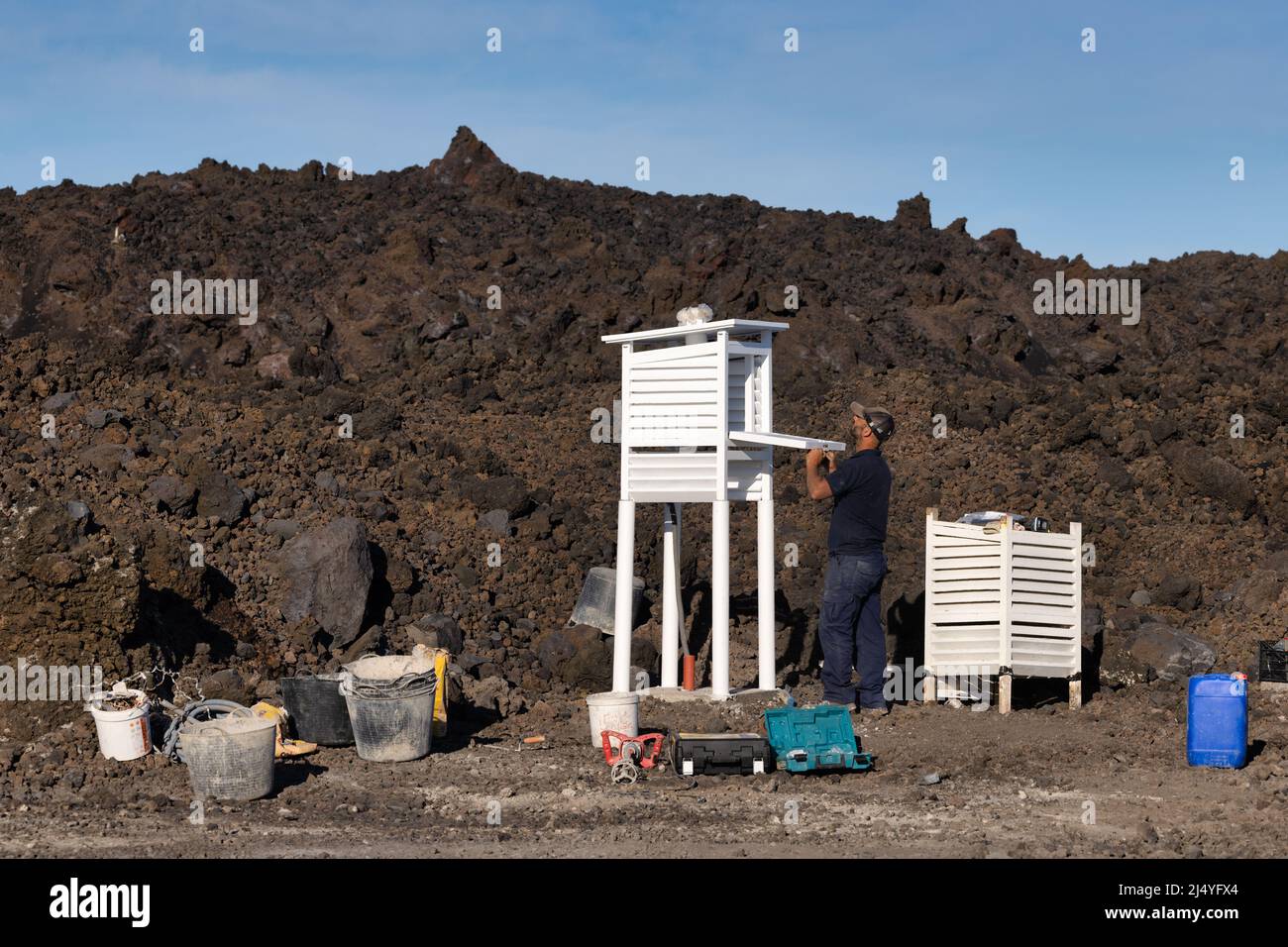 Isla La Palma España - 08 de marzo de 2022: Hombre en el trabajo construyendo una cubierta protectora para instrumentos meteorológicos Foto de stock