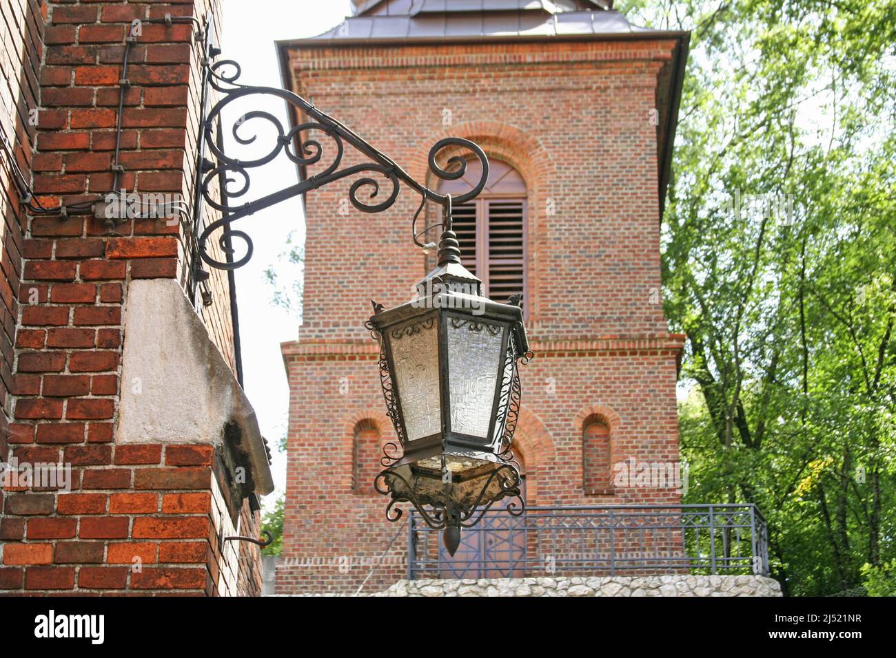Antigua linterna de hierro frente a la Iglesia de San José Una histórica iglesia católica romana en el distrito de Podgorze de Cracovia, Polonia. Foto de stock