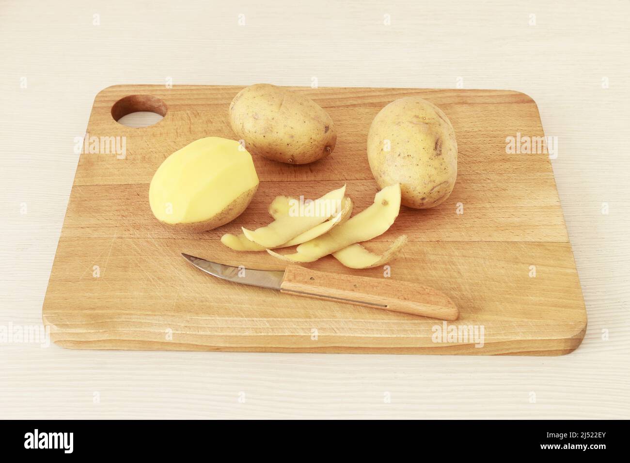 Pelando patatas en una cocina casera. Tiempo de cocción Foto de stock