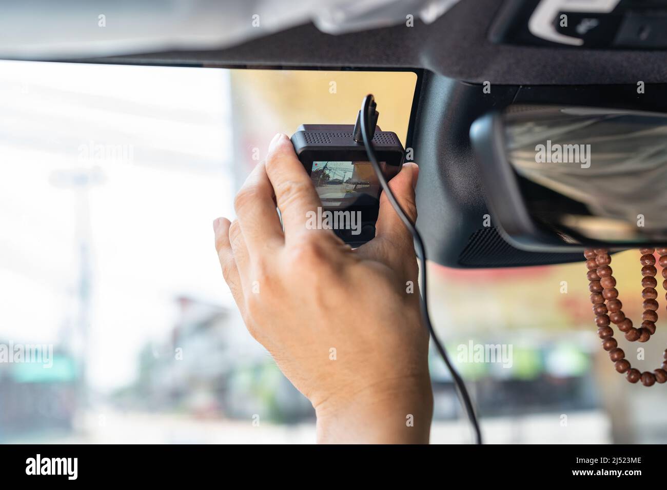 Mano del técnico que instala el grabador de coche con cámara delantera en  el parabrisas del automóvil Fotografía de stock - Alamy