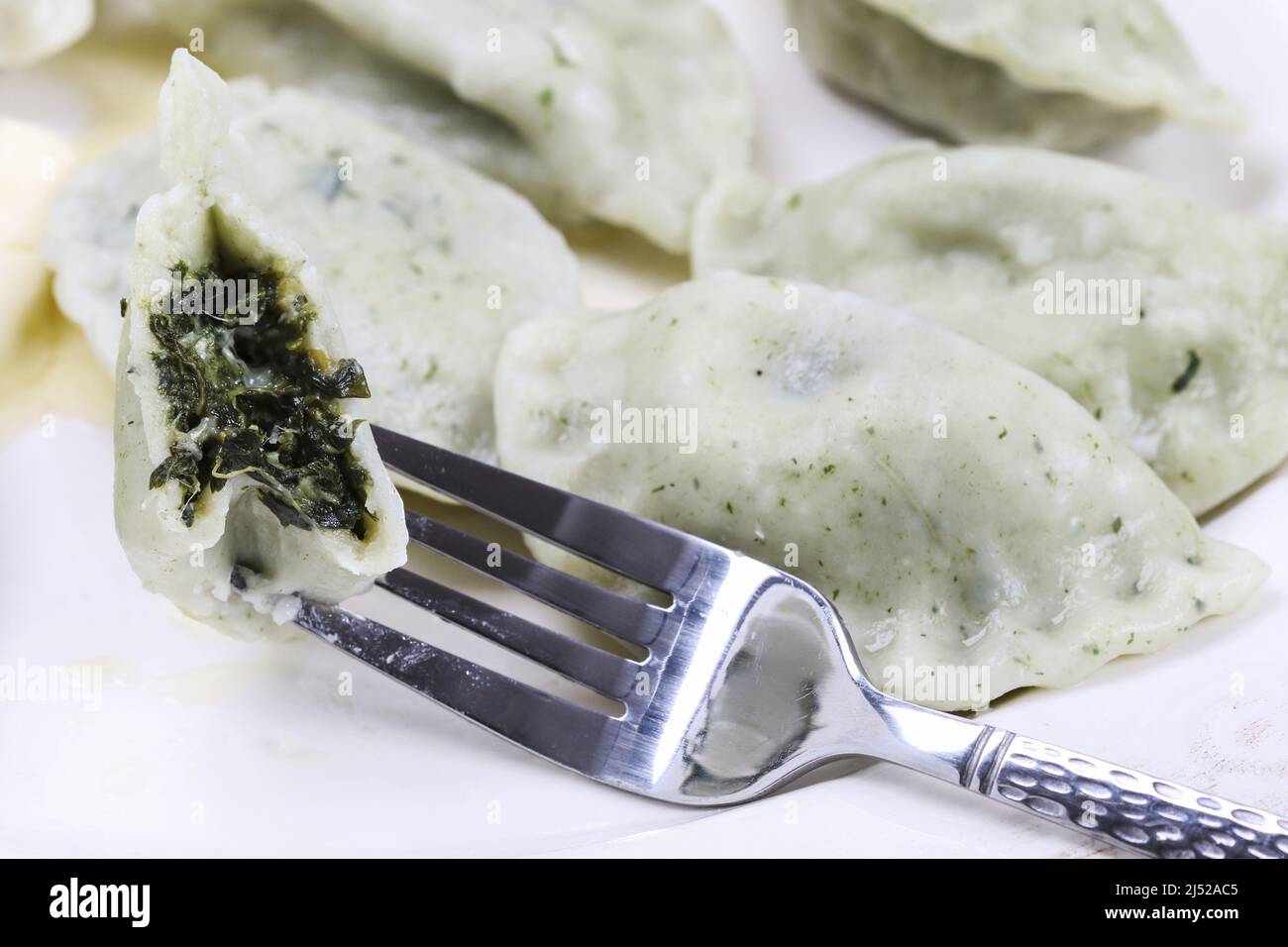 Bolas de masa verdes con espinacas en el plato. Almuerzo plato Foto de stock