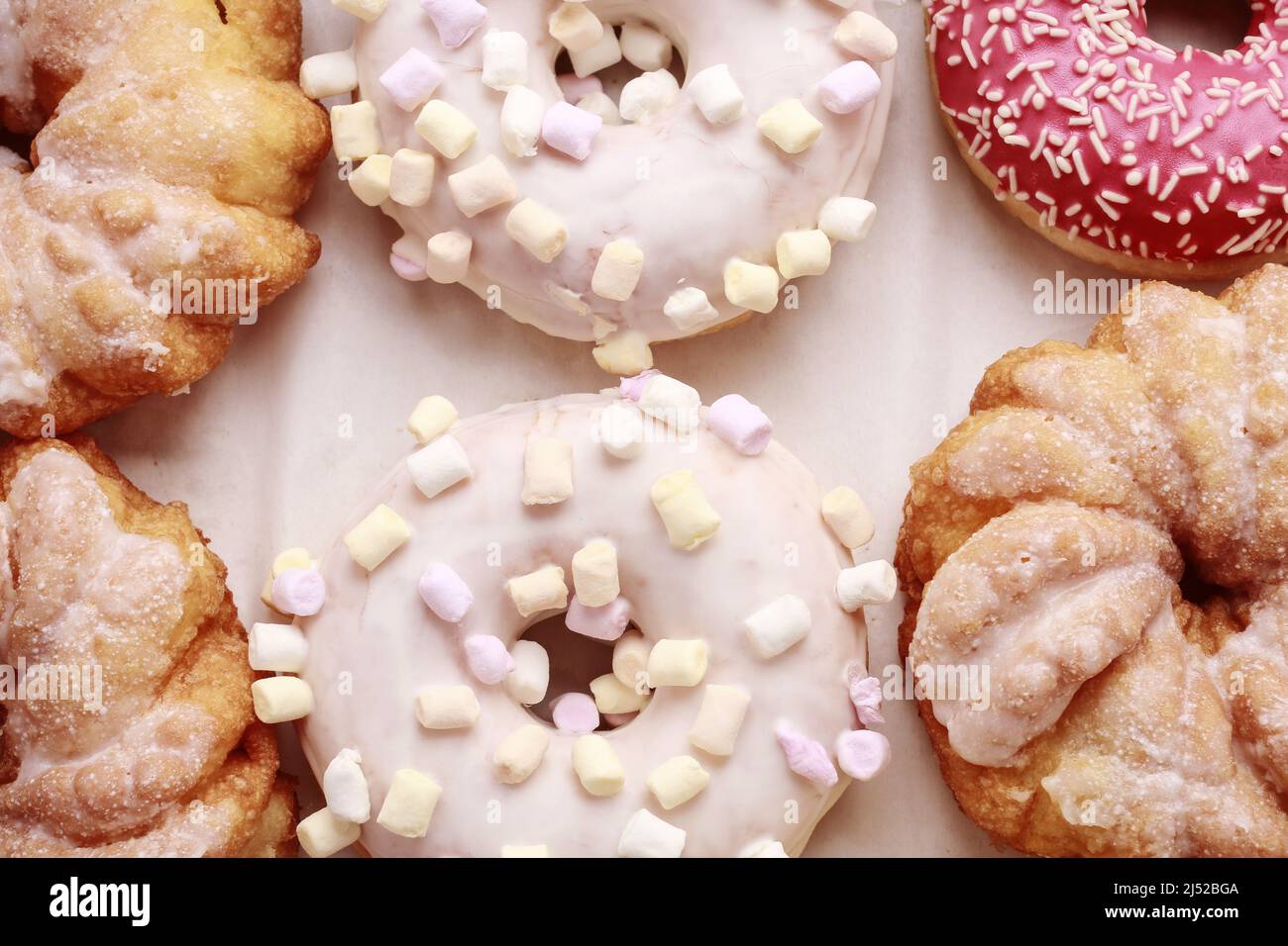 Varios tipos de donuts sobre fondo rosa. Postre de fiesta Foto de stock