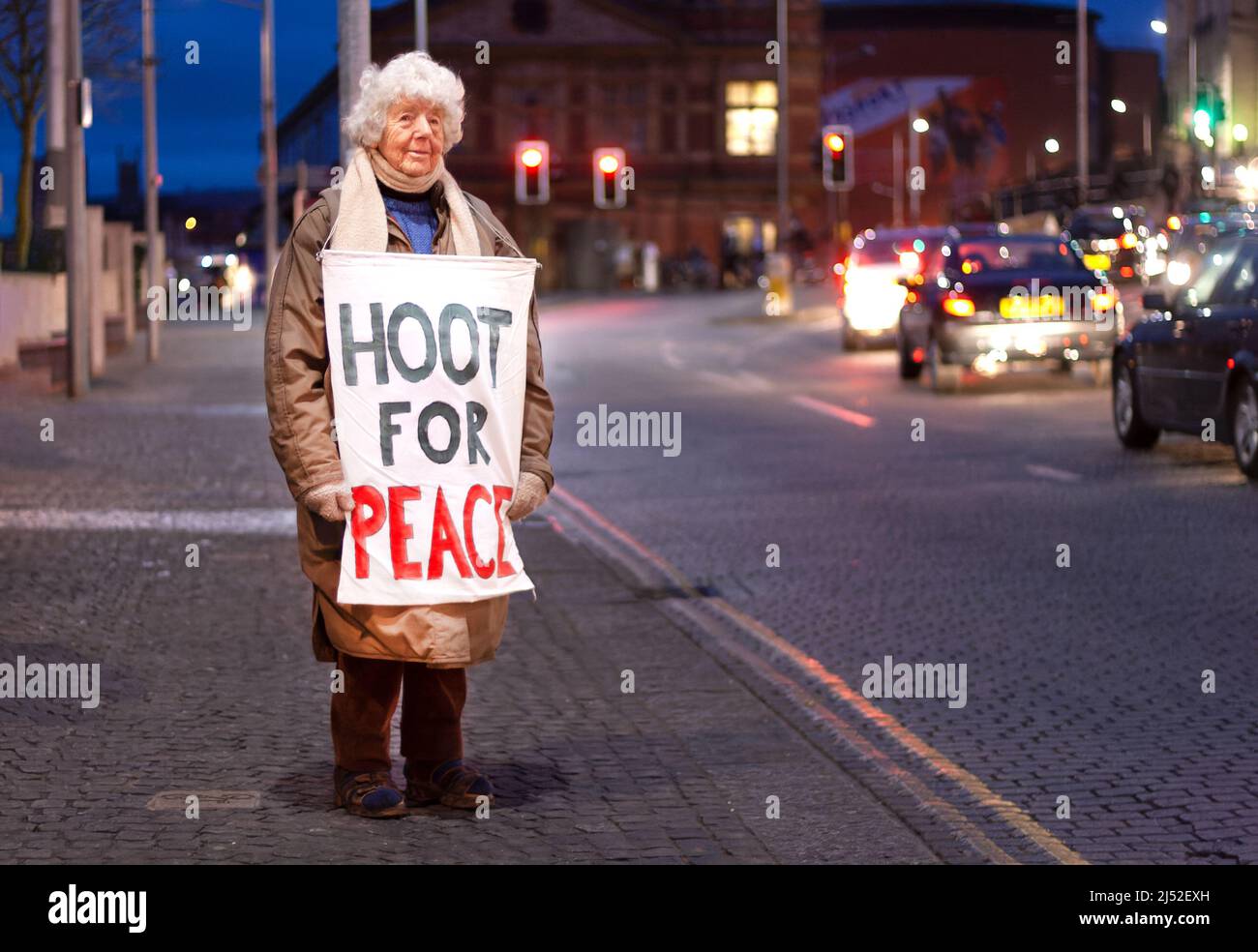 Hoot for Peace, activista, Lois Atherden, de 90 años, espera en su lugar habitual en el centro de Bristol, Reino Unido, frente a conductores que se aproximan Foto de stock