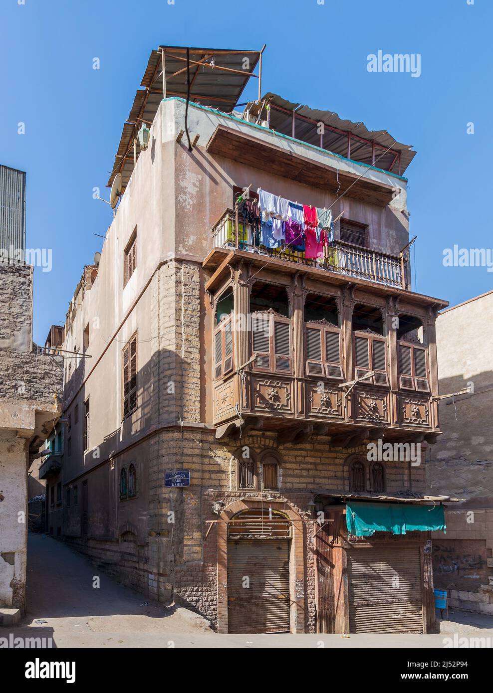 Ventana estilo oriel Mamluk de la era con rejilla de madera intercalada - Mashrabiya, en una pared externa en mal estado, en 1890 edificio residencial histórico conocido como Sokkar House, distrito de Bab Al Wazir, antiguo Cairo, Egipto Foto de stock