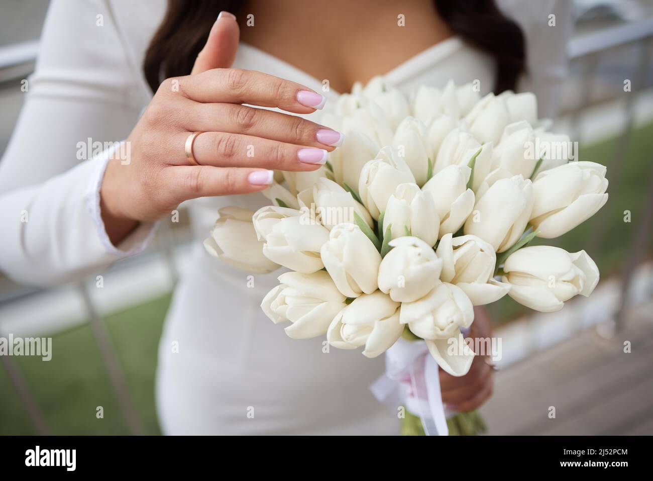 Hermoso gran ramo de tulipanes blancos en las manos de la novia Fotografía  de stock - Alamy