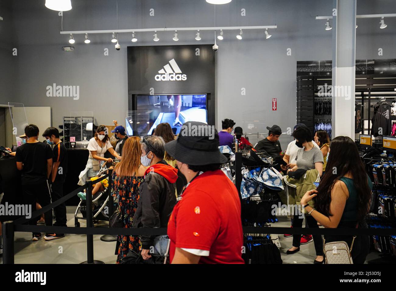 La gente vio ir de compras dentro de una tienda Adidas en el Outlets en  Orange. Mucha gente compra en las tiendas en Orange, para ropa, zapatos,  relojes, bolsas, y mochilas con