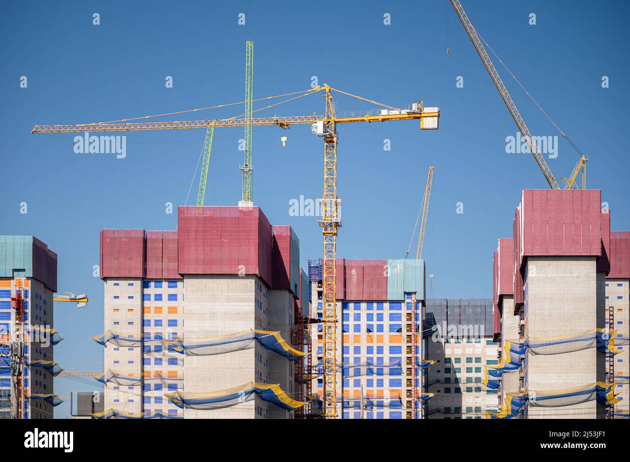 Panorama con muchas grúas torre de construcción en cielo azul claro. Foto de stock