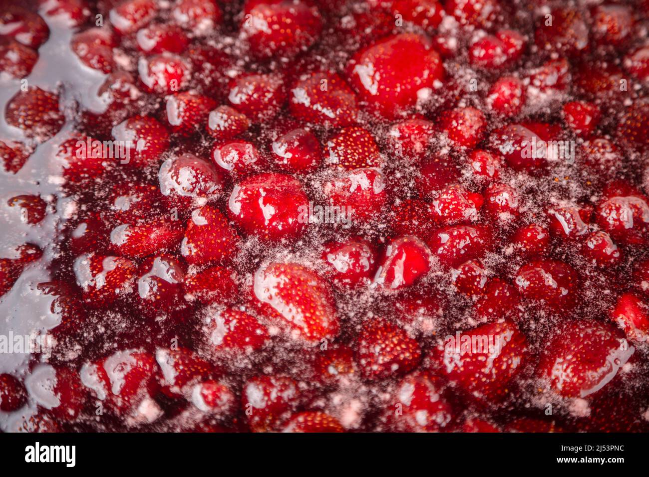 Primer plano de gelatina de fresa hirviendo en una cacerola. Preparación de jalea de fresa, mermelada o salsa de fresa. Haga una mermelada de fresa. Hierva las fresas en la sartén. Enfoque suave, Primer plano Foto de stock