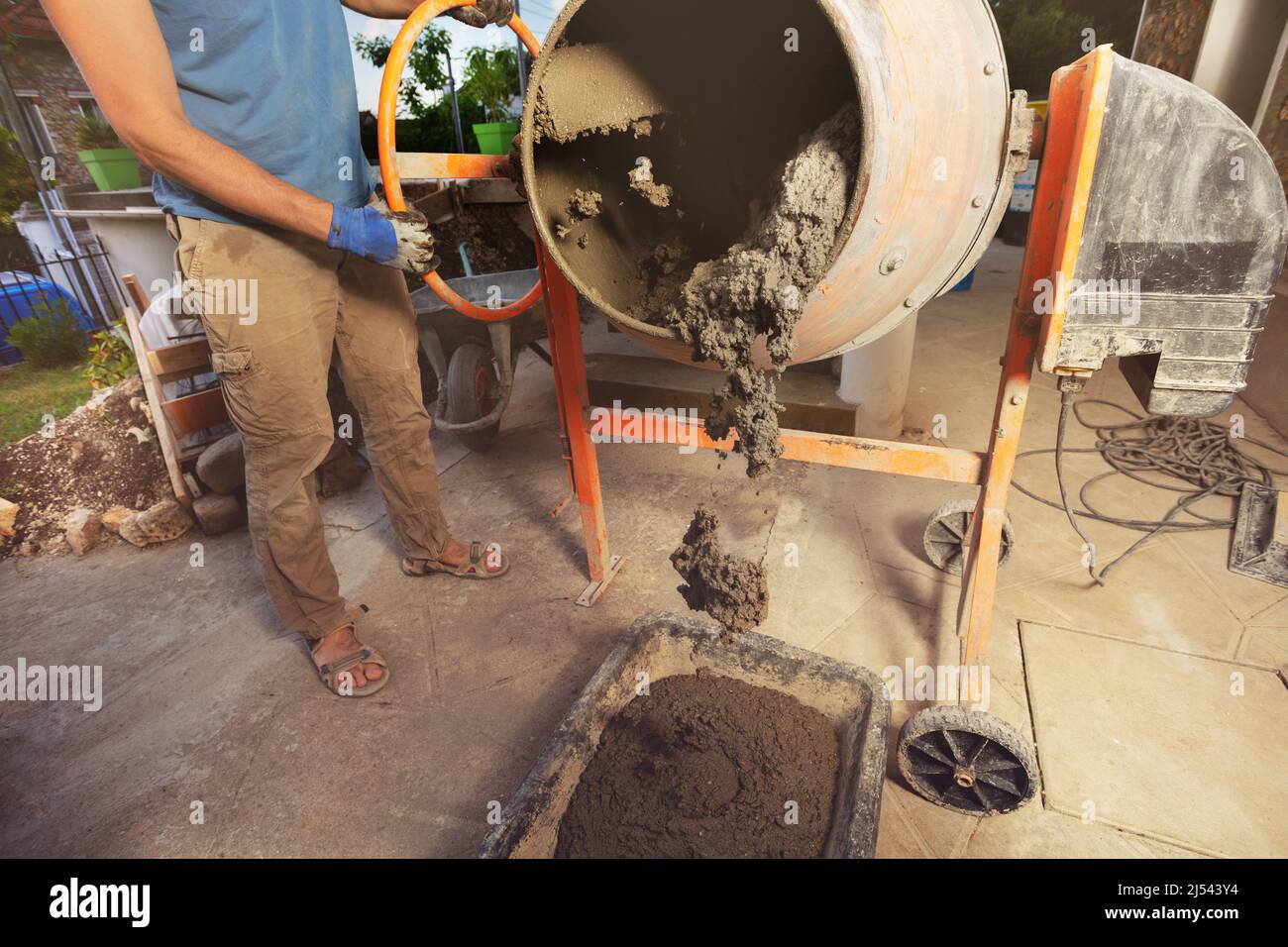 El hombre vierte el hormigón al cubo del cemento en la construcción casera  del bricolaje Fotografía de stock - Alamy