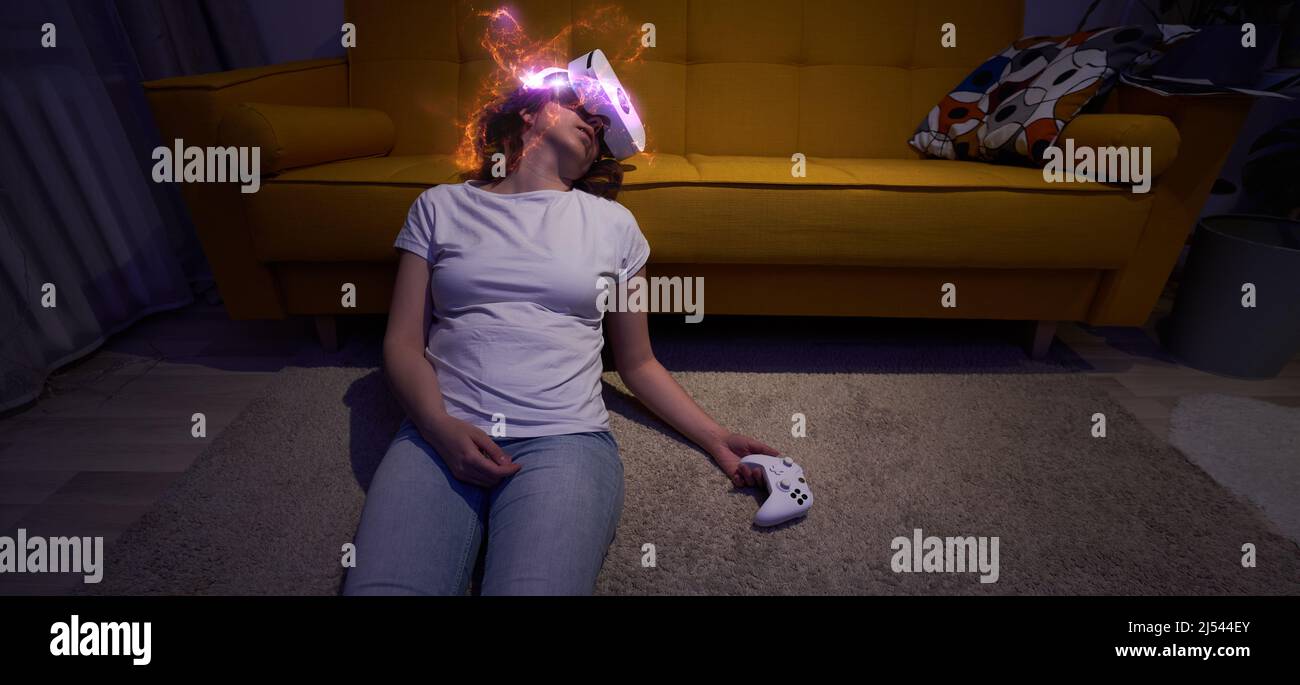 La mujer jugó muchos juegos y se quedó dormida sentada en el suelo sosteniendo el joystick en su mano. Elementos Imagen proporcionada por la NASA. Concepto de juego A Foto de stock