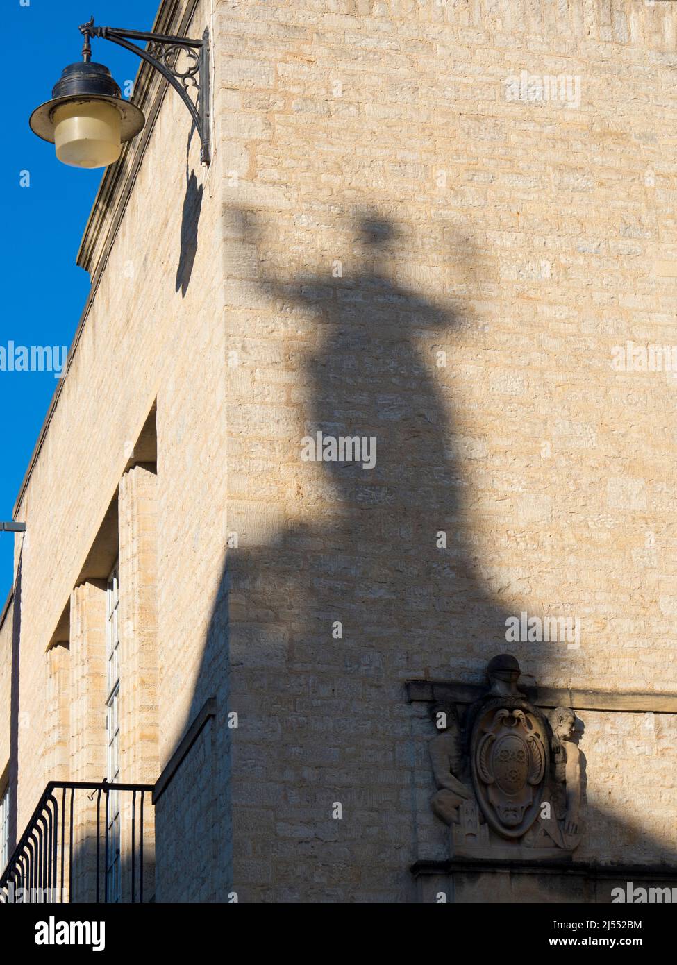 Esta sombra de un ángel proviene de una estatua en el edificio Clarendon de Oxford Central, un centro de administración de la Universidad. Cae en el wal Foto de stock