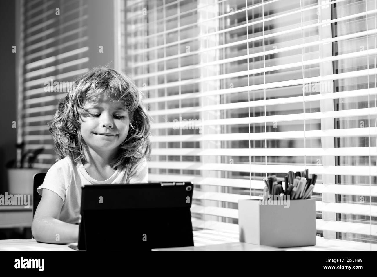 El niño listo para responder a la pregunta de los profesores en línea. E-learning, homeschool y educación en línea para niños. Foto de stock