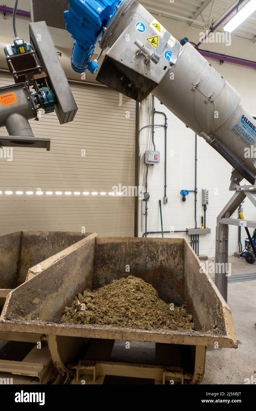 Los residuos de la rejilla del tambor en una SBR o una planta de tratamiento de aguas residuales de reactores de lotes secuenciales caen en un contenedor para su eliminación. Moab, Utah. Foto de stock