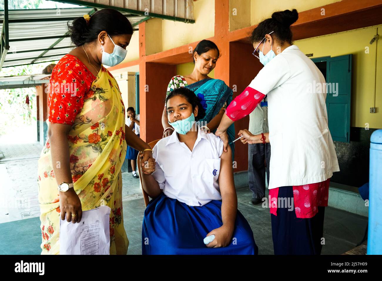 Vacunación En la India, trabajador médico que administra la inyección de la vacuna Sinopharm para proteger contra coronavirus o covid-19 a una niña en Carmel High School for Girls en Baruipur, India Foto de stock