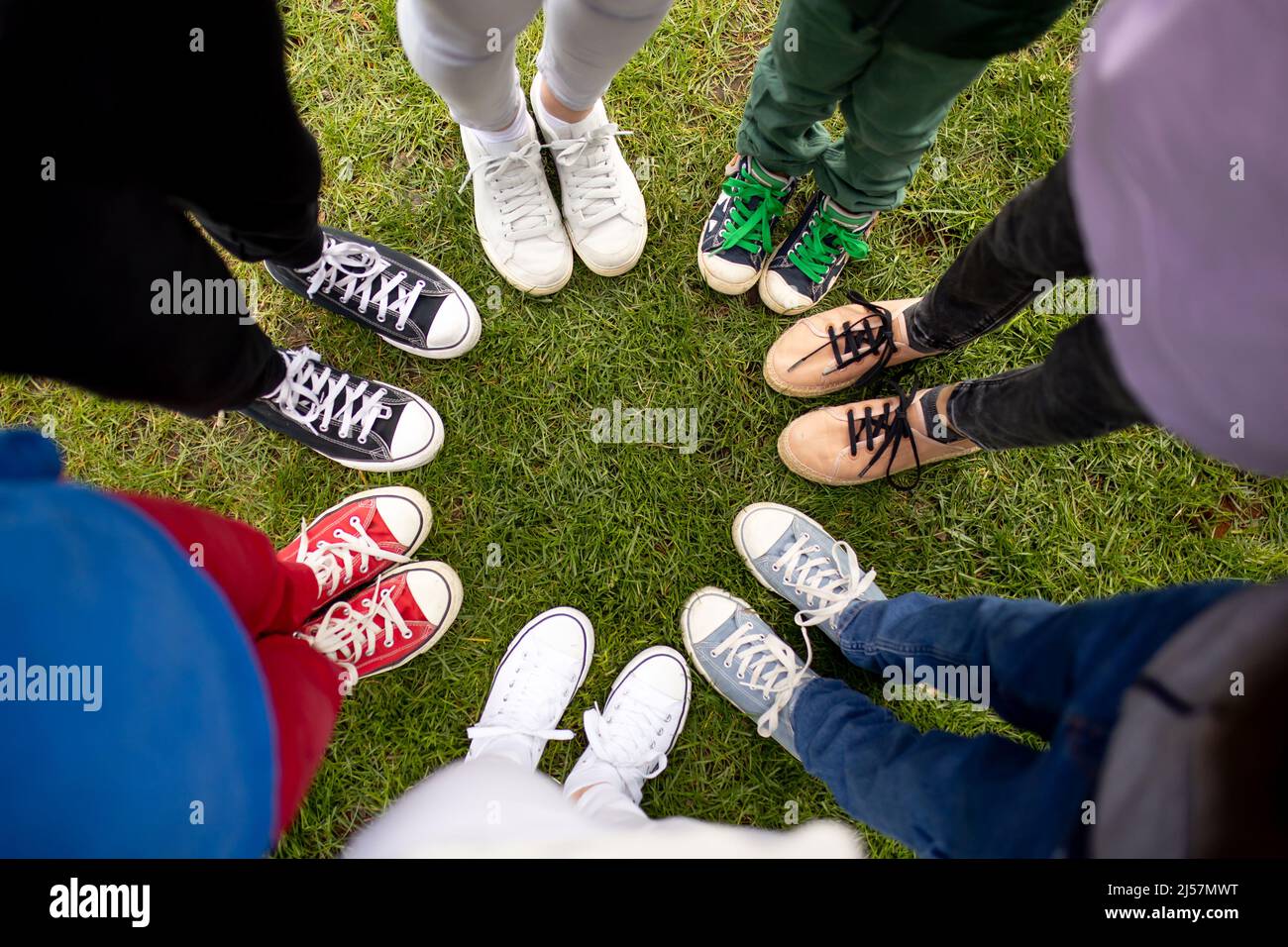 Zapatos coloridos en los pies de los niños. Jóvenes frescos colorido blanco  rosa verde azul negro gris zapatos de gimnasio, personas de pie en círculo,  copiar lugar vista superior Fotografía de stock -
