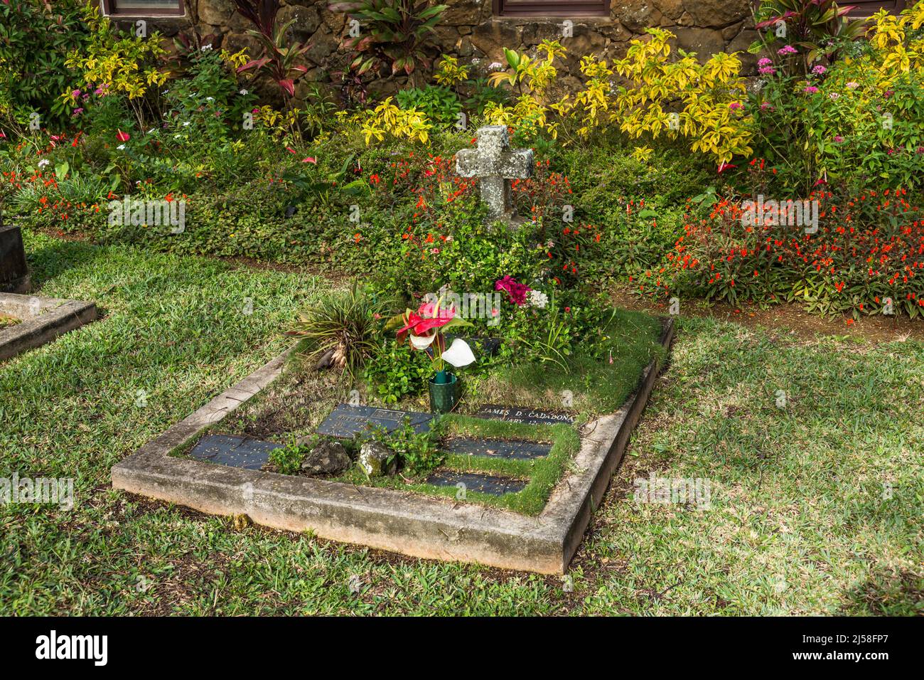 Una tumba en los terrenos de la histórica Iglesia Episcopal Cristo Memorial en Kilauea, Kauai, Hawaii. Foto de stock
