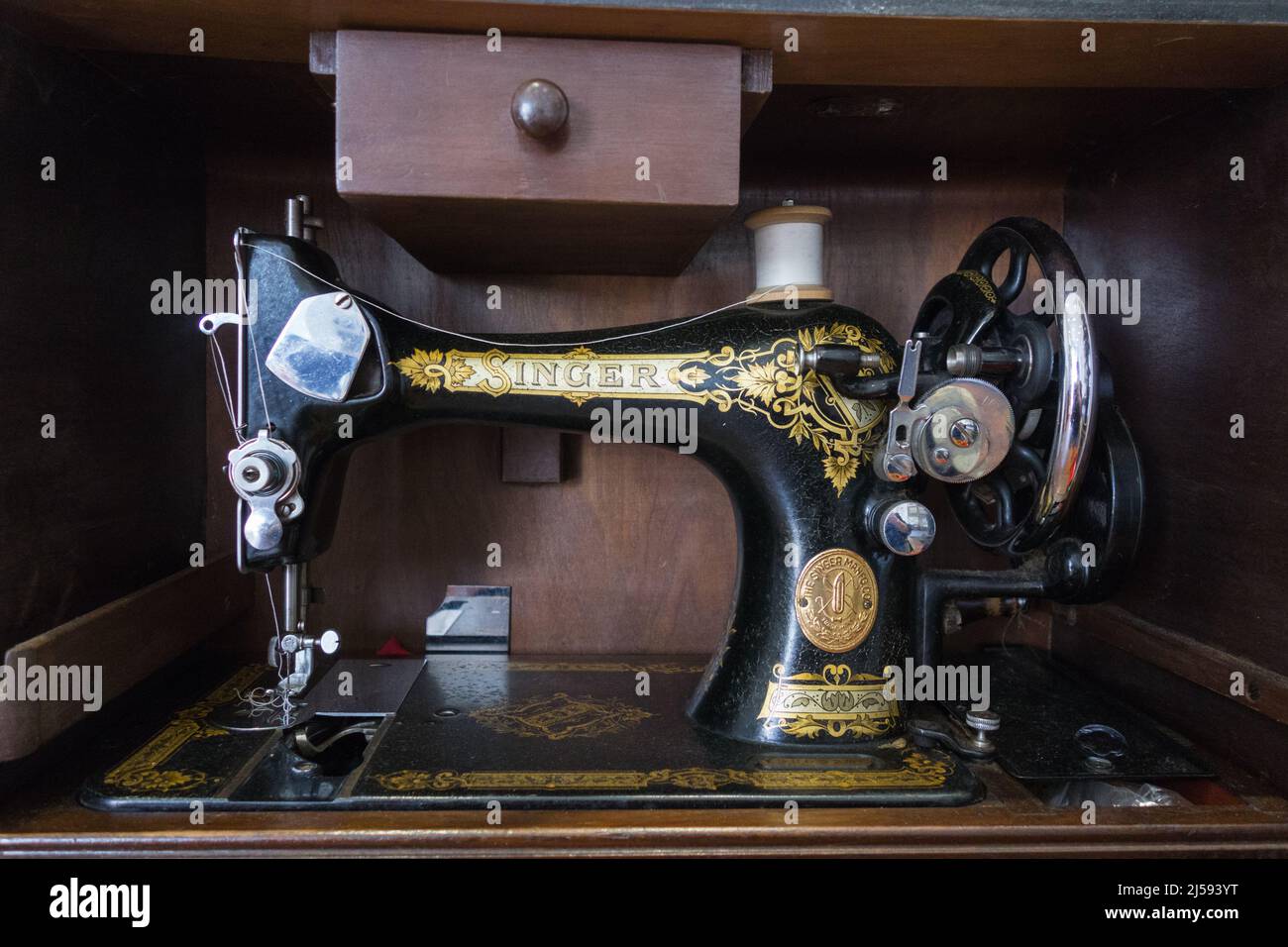 Una máquina de coser Vintage Singer en una caja de madera Mahogany Foto de stock