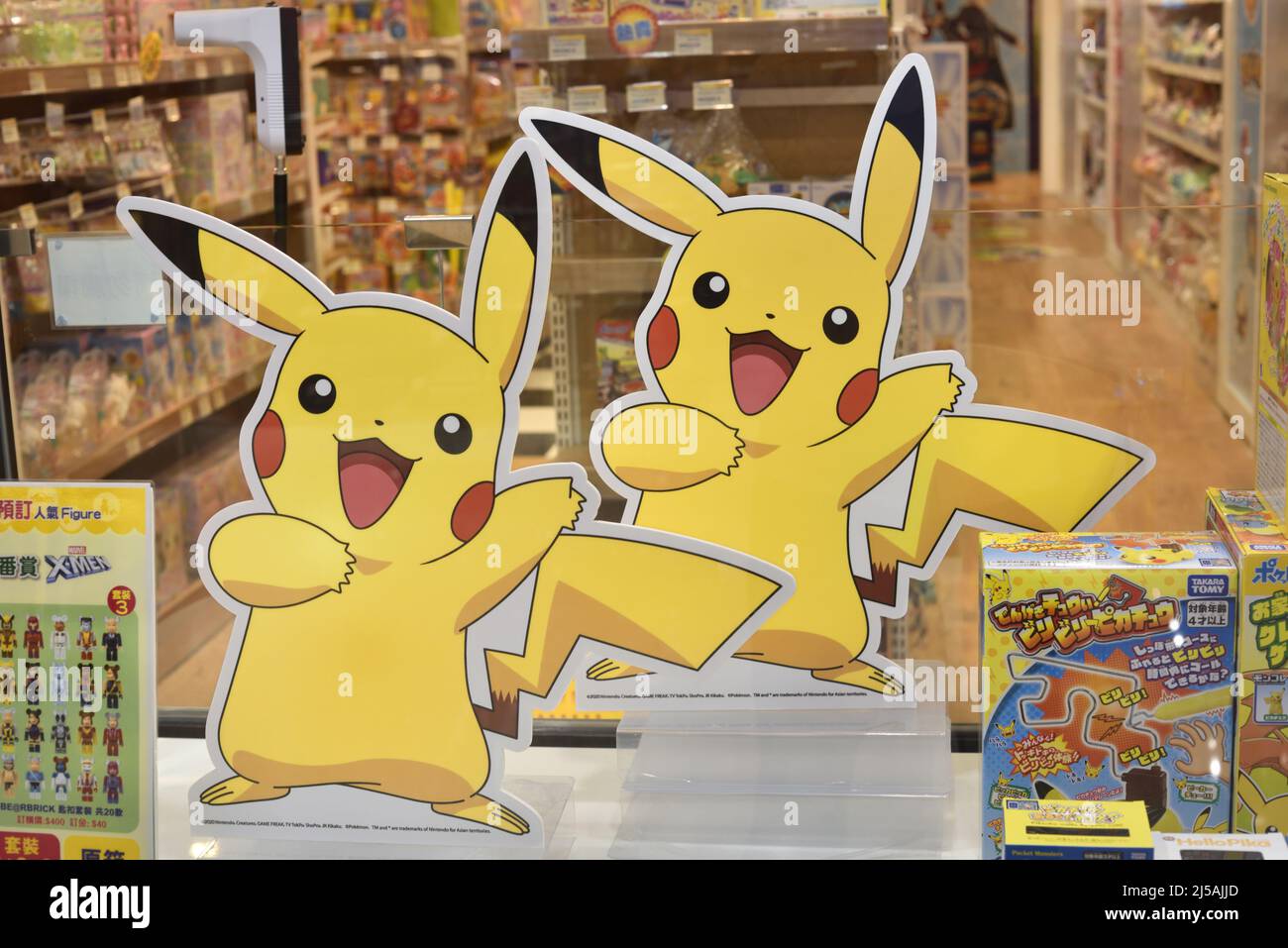 Figuras de cartón de Pikachu gemelo dentro de la ventana de exhibición de una tienda de juguetes Foto de stock