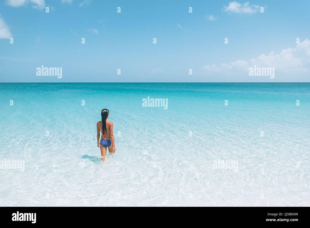 Viaje por la playa, vacaciones en el Caribe. Bikini mujer relajarse tomando el sol en agua bronceándose disfrutando del sol. Vacaciones de invierno Foto de stock